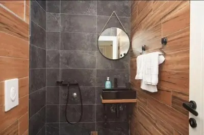 a bathroom with a shower and a sink and a mirror at Casa Calda apartman in Budva