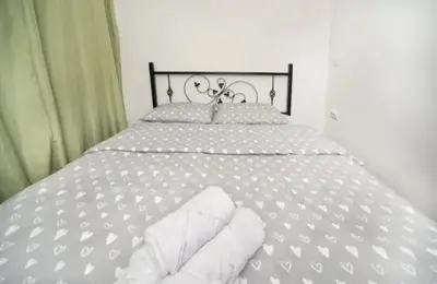 a white bed with white sheets and pillows on it at Casa Calda apartman in Budva
