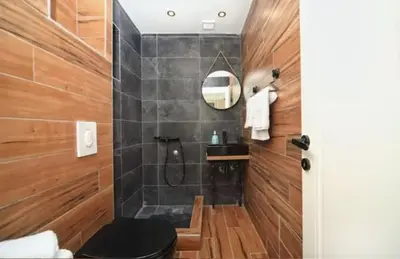 a bathroom with a black toilet and a shower at Casa Calda apartman in Budva
