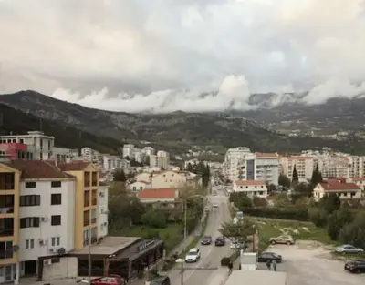 a city with cars driving down a street with buildings at Casa Calda apartman in Budva