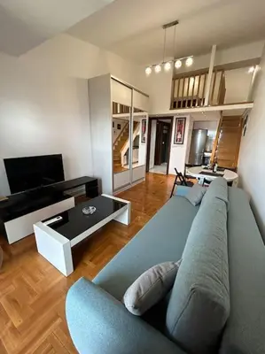 a living room with a blue couch and a tv at Stylish_apartment in Podgorica