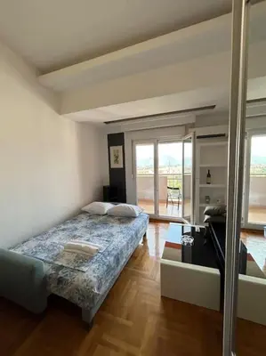a bedroom with a bed in a room with windows at Stylish_apartment in Podgorica