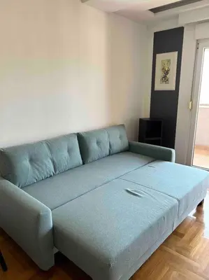 a blue couch sitting in a living room at Stylish_apartment in Podgorica