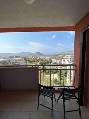 two chairs on a balcony with a view of a city at Stylish_apartment in Podgorica