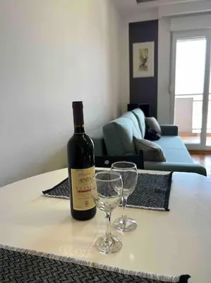 a bottle of wine and two wine glasses on a table at Stylish_apartment in Podgorica