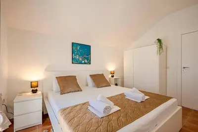 a white bedroom with two beds in a room at Penthouse apartment with panoramic oceanview in Krimovice