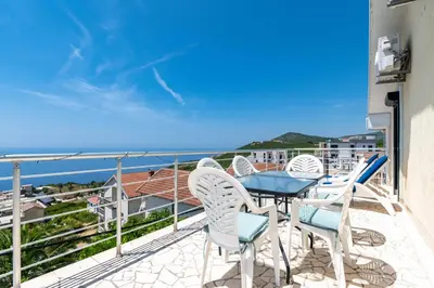 a balcony with a table and chairs and the ocean at Penthouse apartment with panoramic oceanview in Krimovice