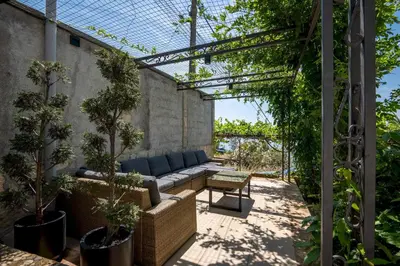 an outdoor patio with a couch and trees at Penthouse apartment with panoramic oceanview in Krimovice