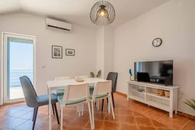 a dining room with a table and chairs and a tv at Penthouse apartment with panoramic oceanview in Krimovice