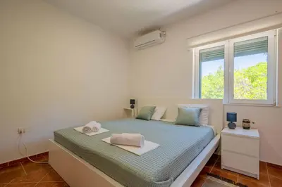 a white bedroom with a bed with a window at Penthouse apartment with panoramic oceanview in Krimovice