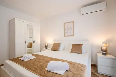 a white bedroom with a large bed and two towels at Vacation home in Budva with fantastic oceanview in Krimovice
