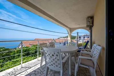 a balcony with a table and chairs and the ocean at Vacation home in Budva with fantastic oceanview in Krimovice