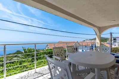 a balcony with a table and chairs and the ocean at Vacation home in Budva with fantastic oceanview in Krimovice