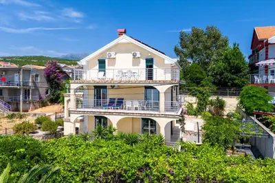 a large white house on a hill with trees at Vacation home in Budva with fantastic oceanview in Krimovice