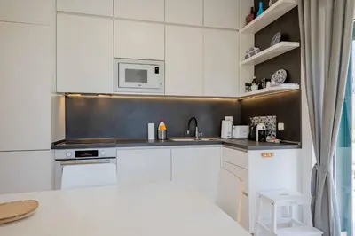 a white kitchen with a sink and a microwave at Vacation home in Budva near the beach in Krimovice