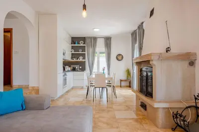 a living room with a fireplace and a table at Vacation home in Budva near the beach in Krimovice