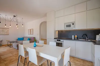 a kitchen and living room with a white table and chairs at Vacation home in Budva near the beach in Krimovice