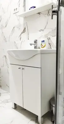 a bathroom with a white sink and marble walls at Blue Skies in Podgorica