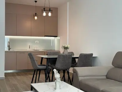 a living room with a table and chairs and a kitchen at K apartments in Becici