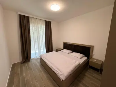 a bedroom with a bed and a large window at K apartments in Becici