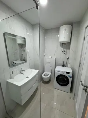 a bathroom with a toilet sink and a washing machine at K apartments in Becici
