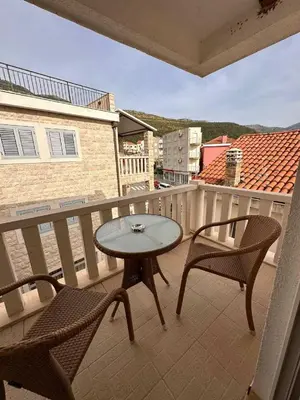 a patio with two chairs and a table on a balcony at Apartments Djuro in Petrovac na Moru