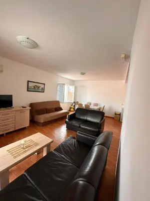 a living room with a leather couch and a table at Apartments Djuro in Petrovac na Moru