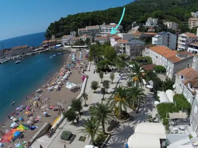 a beach with a crowd of people and the ocean at Apartments Djuro in Petrovac na Moru
