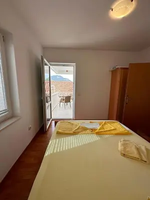 a bedroom with a bed and a door to a balcony at Apartments Djuro in Petrovac na Moru