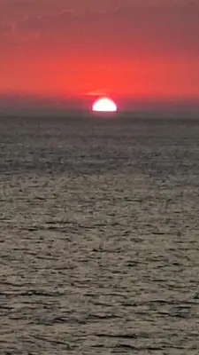 a sunset over the ocean with a red sky at Apartmani Vila Delfin in Dobra Voda