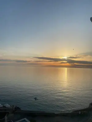 a person in the water at sunset at Apartmani Vila Delfin in Dobra Voda