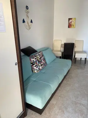 a couch in a room with two chairs at Apartmani Vila Delfin in Dobra Voda