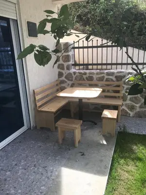 a picnic table and bench next to a building at Apartmani Vila Delfin in Dobra Voda