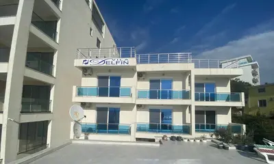 a large white building with a sign on it at Apartments Delfin in Bar