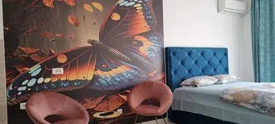 a bedroom with a large butterfly mural next to a bed at Nakiiii apartmanii in Podgorica