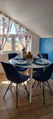 a dining room table with chairs and wine glasses on it at Nakiiii apartmanii in Podgorica