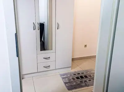 a white cabinet with a mirror in a room at Jasna's Old Town Apartment in Podgorica
