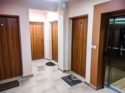 a hallway with wooden doors and a tile floor at Jasna's Old Town Apartment in Podgorica