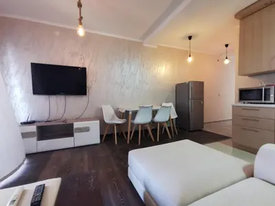 a living room with a kitchen and a table with chairs at Holiday Home Kalicanin in Bar