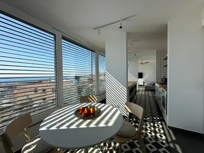 a white table and chairs in a room with windows at MiU Bar Apartment in Donji Susanj