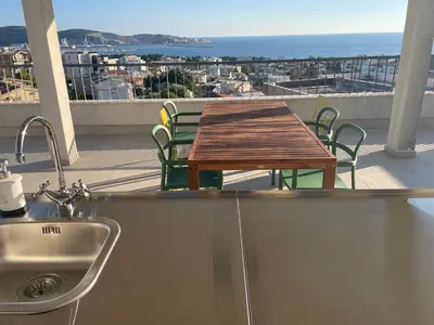 a table and chairs on a balcony with a view of the ocean at MiU Bar Apartment in Donji Susanj