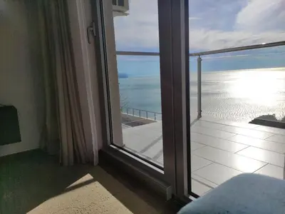 a room with a large window with a view of the ocean at Hillside Apartment with Infinity Pool and Sea View in Budva