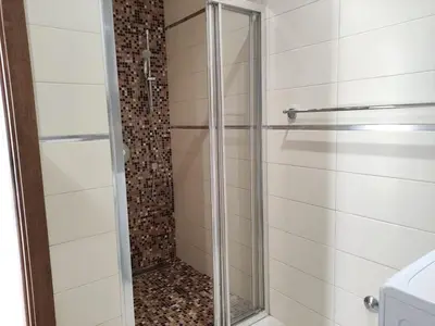 a shower with a glass door in a bathroom at Hillside Apartment with Infinity Pool and Sea View in Budva