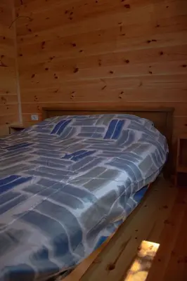 a bed in a room with a wooden wall at River house Bonaca in Ulcinj