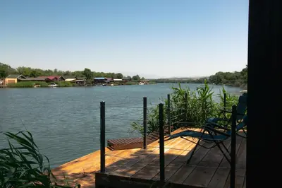 a dock with a chair on top of a body of water at River house Bonaca in Ulcinj