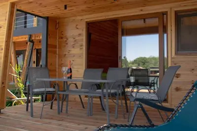 a patio with a table and chairs on a deck at River house Bonaca in Ulcinj
