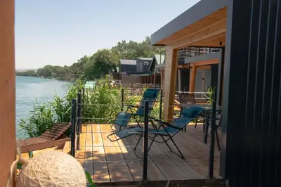 a porch with chairs and a deck with a view of the water at River house Bonaca in Ulcinj