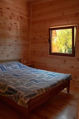 a bed in a log cabin with a window at River house Bonaca in Ulcinj