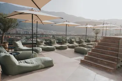 a row of couches and tables and umbrellas at Infinity Hotel & More in Budva