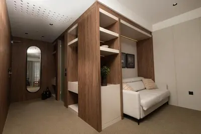 a living room with a couch and a mirror at Infinity Hotel & More in Budva
